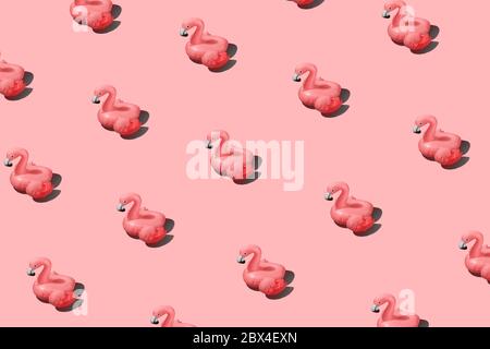 Motif tendance avec flamants roses gonflables sur fond rose Banque D'Images