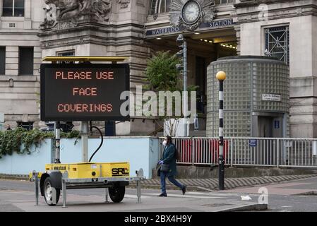 Une affiche demandant aux gens d'utiliser des revêtements de visage à l'extérieur de la gare de Waterloo à Londres, suite à l'annonce que le port d'un revêtement de visage sera obligatoire pour les passagers des transports en commun en Angleterre à partir de juin 15. Banque D'Images