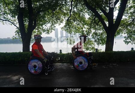 (200605) -- NANCHANG, 5 juin 2020 (Xinhua) -- Xie Junwu (R) et son coéquipier Liang Fei participent au marathon en ligne en fauteuil roulant du marathon international de Nanchang 2020 à Nanchang, capitale de la province de Jiangxi, en Chine orientale, le 31 mai 2020. Xie Junwu, 50 ans, est une formatrice de réadaptation au Centre de réadaptation Jiangxi Leqiu. XIE, qui était handicapé par une lésion de la moelle épinière il y a 28 ans, s'est intéressé aux compétences en fauteuil roulant en 2001 et a mis en place un club pour les coureurs en fauteuil roulant à Nanchang en 2016. XIE et ses coéquipiers ont rejoint le marathon en ligne en fauteuil roulant de l'Inter Nanchang 2020 Banque D'Images