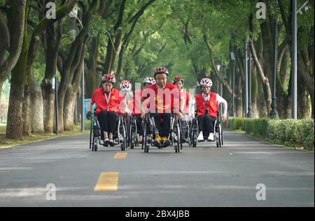 (200605) -- NANCHANG, 5 juin 2020 (Xinhua) -- Xie Junwu (front) et ses coéquipiers participent au marathon en ligne en fauteuil roulant du marathon international de Nanchang 2020 à Nanchang, capitale de la province de Jiangxi, en Chine orientale, le 31 mai 2020. Xie Junwu, 50 ans, est une formatrice de réadaptation au Centre de réadaptation Jiangxi Leqiu. XIE, qui était handicapé par une lésion de la moelle épinière il y a 28 ans, s'est intéressé aux compétences en fauteuil roulant en 2001 et a mis en place un club pour les coureurs en fauteuil roulant à Nanchang en 2016. XIE et ses coéquipiers ont rejoint le marathon en ligne en fauteuil roulant de l'Internatio de Nanchang en 2020 Banque D'Images