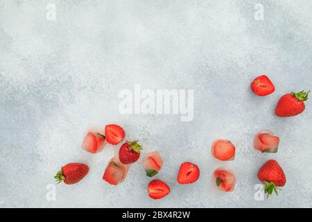 Fraise avec isolé sur fond gris. Pose à plat. Vue de dessus. Baies sucrées d'été avec glace Banque D'Images