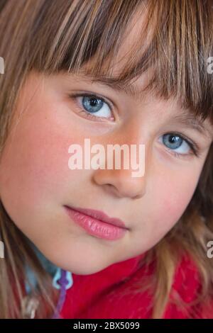 Portrait d'une fille de six ans regardant directement l'appareil photo.