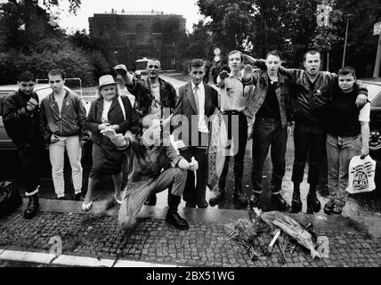 Berlin-Spandau / Nazis / groupes de droite 20.8.1987 devant la prison des criminels de guerre de Spandau, Rudolf Hess vient de mourir. Les groupes de droite se rassemblent en deuil. Le jeune radical de droite Michael Wendt (à droite) avec le drapeau de guerre de Reich et le salut de Kuehnen, une variante du salut d'Hitler, qui a été interdit. Un policier demande ce que c'est. Fleurs devant pour Hess. // nazi / fascisme / *** Légende locale *** la prison pour les criminels de guerre à Berlin-Spandau. Le dernier prisonnier, Rudolf Hess, est mort juste après 46 ans dans la prison montrée en arrière-plan. Aile droite Banque D'Images