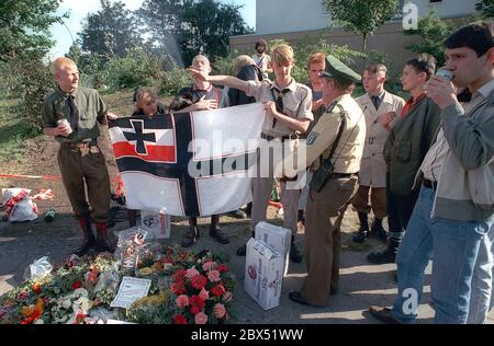 Berlin-Spandau / Nazis / groupes de droite 20.8.1987 devant la prison des criminels de guerre de Spandau, Rudolf Hess vient de mourir. Les groupes de droite se rassemblent en deuil. Le jeune radical de droite Michael Wendt (à droite) avec le drapeau de guerre de Reich et le salut de Kuehnen, une variante du salut d'Hitler, qui a été interdit. Un policier demande ce que c'est. Fleurs devant pour Hess. // nazi / fascisme / *** Légende locale *** la prison pour les criminels de guerre à Berlin-Spandau. Le dernier prisonnier, Rudolf Hess, est mort juste après 46 ans dans la prison montrée en arrière-plan. Aile droite Banque D'Images