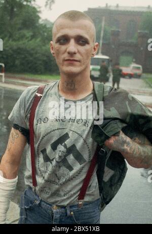 Berlin-Spandau / Nazis / groupes de droite 20.8.1987 devant la prison des criminels de guerre de Spandau, Rudolf Hess vient de mourir. Les groupes de droite se rassemblent en deuil. Une tête de peau avec un T-shirt portant un portrait d'Hitler, une croix gammée et l'inscription suivante: -pas de remords-, -pas de regrets- // nazi / fascisme / *** Légende locale *** la prison pour les criminels de guerre à Berlin-Spandau. Le dernier prisonnier, Rudolf Hess, est mort juste après 46 ans dans la prison montrée en arrière-plan. Les gens de droite se rassemblent pour pleurer. Cette tête de peau est dotée d'un t-shirt avec une croix gammée, une photo d'hitler et Banque D'Images