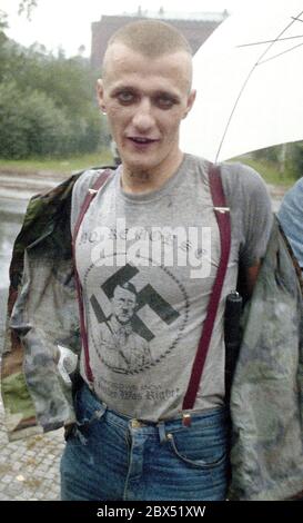 Berlin-Spandau / Nazis / groupes de droite 20.8.1987 devant la prison des criminels de guerre de Spandau, Rudolf Hess vient de mourir. Les groupes de droite se rassemblent en deuil. Une tête de peau avec un T-shirt portant un portrait d'Hitler, une croix gammée et l'inscription suivante: -pas de remords-, -pas de regrets- // nazi / fascisme / *** Légende locale *** la prison pour les criminels de guerre à Berlin-Spandau. Le dernier prisonnier, Rudolf Hess, est mort juste après 46 ans dans la prison montrée en arrière-plan. Les gens de droite se rassemblent pour pleurer. Cette tête de peau est dotée d'un t-shirt avec une croix gammée, une photo d'hitler et Banque D'Images