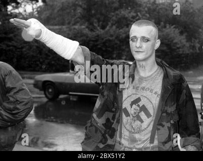 Berlin-Spandau / Nazis / groupes de droite 20.8.1987 devant la prison des criminels de guerre de Spandau, Rudolf Hess vient de mourir. Les groupes de droite se rassemblent en deuil. Une tête de peau avec un T-shirt portant un portrait d'Hitler, une croix gammée et l'inscription suivante: -pas de remords-, -pas de regrets- // nazi / fascisme / *** Légende locale *** la prison pour les criminels de guerre à Berlin-Spandau. Le dernier prisonnier, Rudolf Hess, est mort juste après 46 ans dans la prison montrée en arrière-plan. Les gens de droite se rassemblent pour pleurer. Cette tête de peau est dotée d'un t-shirt avec une croix gammée, une photo d'hitler et Banque D'Images