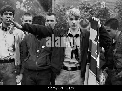 Berlin-Spandau / Nazis / groupes de droite 20.8.1987 devant la prison des criminels de guerre de Spandau, Rudolf Hess vient de mourir. Les groupes de droite se rassemblent en deuil. Le jeune radical de droite Michael Wendt (à droite) avec le drapeau de guerre de Reich et le salut de Kuehnen, une variante du salut d'Hitler, qui a été interdit. Un policier demande ce que c'est. Fleurs devant pour Hess. // nazi / fascisme / *** Légende locale *** la prison pour les criminels de guerre à Berlin-Spandau. Le dernier prisonnier, Rudolf Hess, est mort juste après 46 ans dans la prison montrée en arrière-plan. Aile droite Banque D'Images