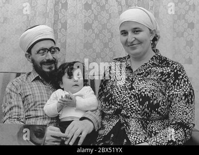 Berlin / étrangers / Islam / 1981 Imam Mustafa Yuekcel et enfant, avec une femme allemande qui s'est convertie à l'Islam. Yuekcel est un imam indépendant qui donne des leçons de Coran dans son appartement. Les circoncisions sont également effectuées. Il est diplômé d'une université du Caire. // Turcs / fondamentalistes / femmes / foulard / famille / couple [traduction automatique] Banque D'Images