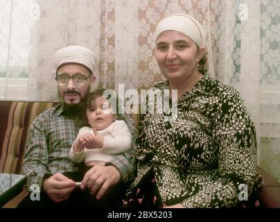 Berlin / étrangers / Islam / 1981 Imam Mustafa Yuekcel et enfant, avec une femme allemande qui s'est convertie à l'Islam. Yuekcel est un imam indépendant qui donne des leçons de Coran dans l'appartement. Les circoncisions sont également effectuées. Il est diplômé d'une université du Caire. // Turcs / fondamentalistes / femmes / foulard / famille / couple [traduction automatique] Banque D'Images