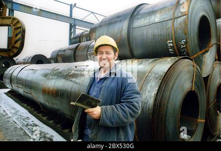 Saxe-Anhalt / GDR-Land / Industrie / décembre 1989 Bitterfeld, usines industrielles et moissonneuse-batteuse de pipeline, usine de Muldenstein. Ici, de gros tuyaux ont été fabriqués, par exemple pour les pipelines de pétrole. Un travailleur devant des rouleaux en acier. L'usine a produit des revêtements intérieurs résistants, mais le directeur n'a pas pu gagner à travers les comités SED. Il a ensuite participé aux manifestations du lundi à Leipzig contre le régime SED. L'usine de Muldenstein était moderne et elle fut vendue à Mannesmann par la Treuhand après la réunification. La principale usine de Bitterfeld a été démolie. // travailleurs / Métal / [automatisé Banque D'Images