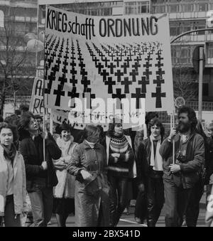 Berlin / 1980-ies / 4.4.1983 Marche de Pâques sur Tauentzienstrasse. La manifestation s'inscrivait dans le cadre de la campagne contre le réarmement, l'armement et le stationnement de missiles nucléaires en Allemagne de l'Ouest. Une affiche de la jeunesse catholique -la guerre crée l'ordre- avec des rangées de croix // gauche / la guerre / Catholiques / désarmement / mouvements de paix / alliés [traduction automatique] Banque D'Images