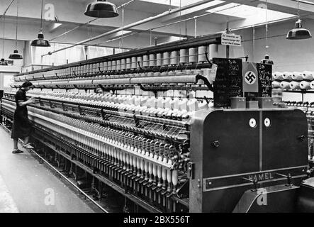 La photographie a été prise à Reichenberg (aujourd'hui Liberec), qui faisait partie du Sudetenland annexé en octobre 1938. Il présente le moulin à laine de l'usine textile Liebig & Co, qui était équipé de machines à tourner considérées comme modernes pour les normes de l'époque. Sur le côté droit de la machine se trouve une instruction de travail : « la lubrification des bagues de torsion Hamel ne peut être effectuée qu'avec de l'huile Etna ». Banque D'Images