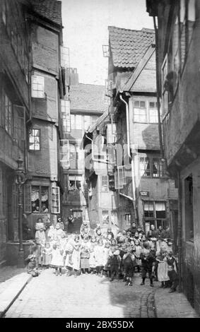 La photo montre une arrière-cour dans la nouvelle ville du sud de Hambourg, qui doit être démolie. Des milliers d'enfants grandissent dans la pauvreté dans les ruelles sombres entre les maisons. Les femmes de ménage regardent par les fenêtres. La misère n'a été surmontée que dans les sous-sols modernes d'alors. Vers 1990. Banque D'Images