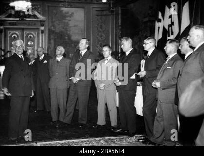 Au cours d'une visite à l'exposition universelle de Paris, les éditeurs de journaux allemands sont reçus par le grand journal « le Journal » et accueillis par le secrétaire général du « Journal » de Marsilliao (à gauche) dans la salle de banquet, qui est décorée, entre autres, de drapeaux. Banque D'Images