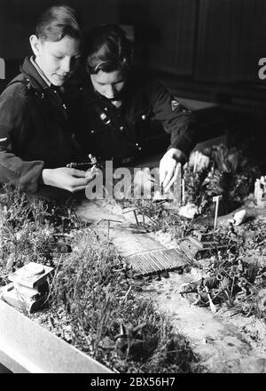 Deux étudiants de la Westendschule Eberswalde à leur travail de bac à sable pour l'exposition "Ran den Sandkasten" de l'Association nationale des enseignants socialistes (Administration Reich, Bureau de liaison Berlin). Il représente une traversée de rivière avec des sacs de radeau et des ponts de fortune. En plus de cela, les soldats et les tanks de jouet. Banque D'Images