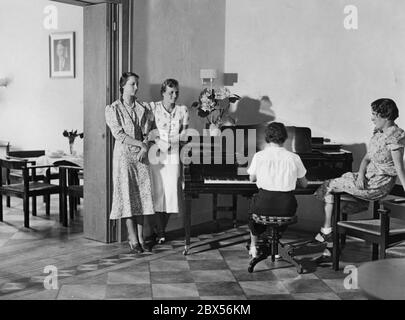 Étudiants de l'Association du travail des étudiantes socialistes nationales (Arbeitsgemeinschaft nationalsozialistischer Studentinnen) dans la salle de musique de leur nouveau dortoir à Berlin C, Oranienburgerstrasse 19. Sur le mur de gauche se trouve un portrait d'Adolf Hitler. Banque D'Images