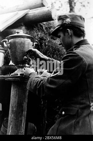 Un soldat de montagne, probablement membre du Jagdkommando 8 (Hunting Commando 8), se verse un thé d'un samovar à Kholm. Pendant la bataille d'encerclement de Kholm, le 'Kampfgruppe Scherer' a défendu avec succès la ville pendant 105 jours. (Photo de la compagnie de propagande (PK) par le correspondant de guerre Richard Muck, qui a pris l'avion dans la poche au début du mois de mars). Banque D'Images