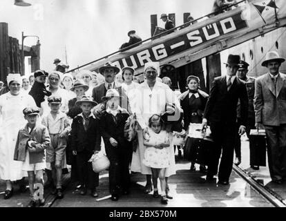 Après l'arrivée des 600 Allemands de Reich du Brésil et de l'Argentine, Qui est arrivé dans le port de Hambourg sur le bateau à moteur 'Monte Olivia', les membres du département de navigation des petits enfants de la Ligue nationale socialiste des femmes s'occupent des petits enfants et des adultes nécessiteux parmi les rapatriés. Banque D'Images