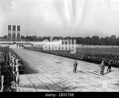 Adolf Hitler (en face), Viktor Lutze (à gauche) et Heinrich Himmler (à droite) défilent à travers la garde d'honneur de la sa de la tribune de l'arène de Luitpold à la cérémonie de pose de couronne et de commémoration des morts à l'Ehrenhalle (salle d'honneur). Banque D'Images