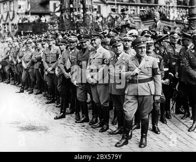 De droite à gauche : Martin Bormann, Robert Ley, Wilhelm Frick, Hans Frank, Franz Ritter von EPP et Joseph Goebbels regardent la parade des formations nazies sur la place du marché principal de Nuremberg. 3ème rangée à droite, Adjutant Julius Schaub. En arrière-plan, le Schoener Brunnen. Banque D'Images