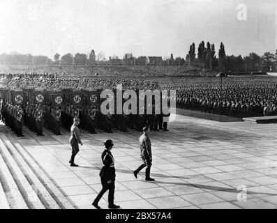 Adolf Hitler (avant), Viktor Lutze (gauche) et Heinrich Himmler (droite) mars passé les normes de l'AS de la tribune de l'arène de Luitpold à la cérémonie de pose de couronne et la commémoration des morts à l'Ehrenhalle (salle d'honneur). Banque D'Images