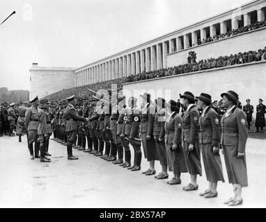 Adolf Hitler salue les dirigeants du Service du travail de Reich sur le terrain de Zeppelin à l'appel nominal du Service du travail de Reich. Derrière Hitler se trouvent Wilhelm Frick et Konstantin Hierl. Une caméra sur le stand de la tribune filme l'événement. Banque D'Images