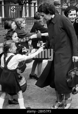 L'anniversaire d'Adolf Hitler, cette année est tombé un samedi. À cette occasion, les enfants présentent des fleurs aux travailleurs qui vont travailler dans l'industrie de l'armement. Banque D'Images