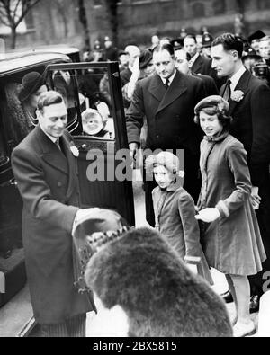 Elizabeth II (à droite) avec sa sœur la princesse Margaret Rose, le roi George VI (devant) et la reine Elizabeth (cachée) sur leur chemin vers le mariage de Cecilia Bowes-Lyon, la fille aînée de Lord Glamis Timothy-Lyon et de M. Kenneth Harington à l'église de la Sainte Trinité. Banque D'Images