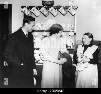 Le roi George VI et la reine Elizabeth sont à Shoreditch pour des visites surprises. La photo montre le couple royal en conversation avec Mme Whitaker dans son petit appartement à Shoreditch Council. Banque D'Images