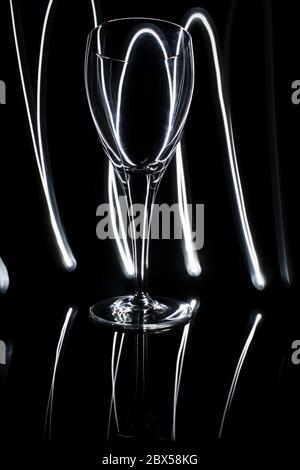 Belle peinture légère avec verre d'eau sur fond noir Banque D'Images