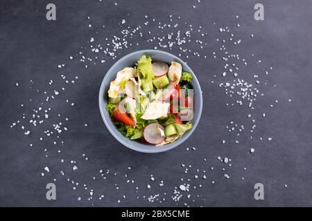 Salade végétarienne Fattoush dans un bol gris sur fond noir. Vue de dessus. Fattoush de la salade Levantine, préparé à partir de pita séché ou de pita avec Banque D'Images