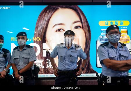 Des policiers sont vus sous garde à l'intérieur de la station de métro MTR pendant la commémoration de la place Tian'anmen au parc Victoria de Causeway Bay, Hong Kong, le 04 juin 2020. Des milliers de personnes à travers Hong Kong se sont rassemblées et ont allumé des bougies le 4 juin pour commémorer le massacre de Tiananmen malgré l'interdiction du gouvernement contre les rassemblements. Banque D'Images