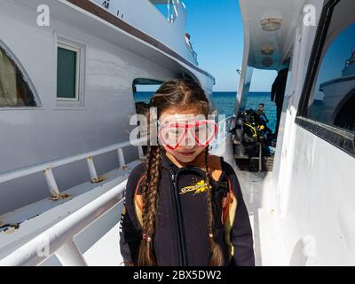 Hurghada, Egypte - 6 janvier 2017 : une fille de huit ans avec un masque de plongée et de longues tresses brunes profite d'une excursion d'une journée sur la mer Rouge avec un bateau de plongée Banque D'Images