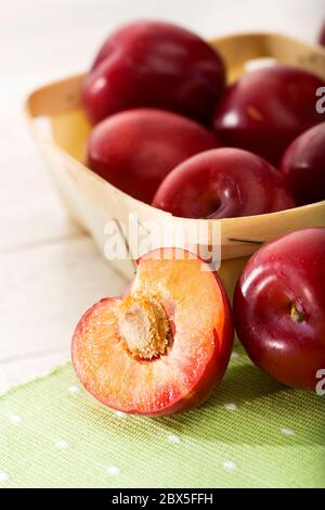 prunes rouges dans un petit panier, gros plan Banque D'Images