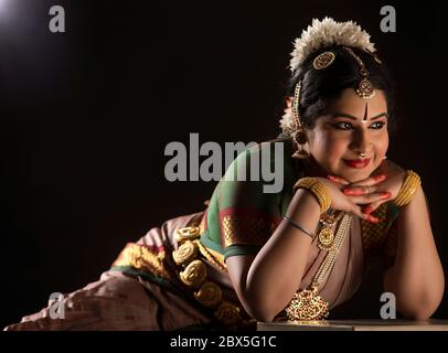 Bharatnatyam danseuse assise avec élégance pendant son spectacle. Banque D'Images