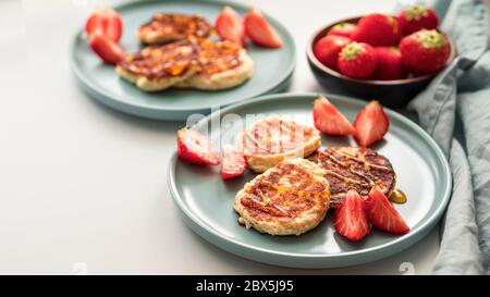 Crêpes au fromage sur l'assiette fraises servies. Crêpes au fromage cottage, syrniki, beignets à la ricotta, beignets au caillé, espace de copie pour le texte ou le dessin. Banque D'Images