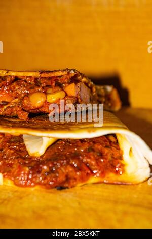 Quesadilla avec bœuf haché, saucisse, haricots rouges, maïs doux, oignon et sauce tomate. Un repas mexicain traditionnel. Gros plan Banque D'Images