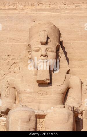 Figurine assise, statue. Entrée du temple Abu Simbel de Ramses II au lever du soleil, en Égypte Banque D'Images