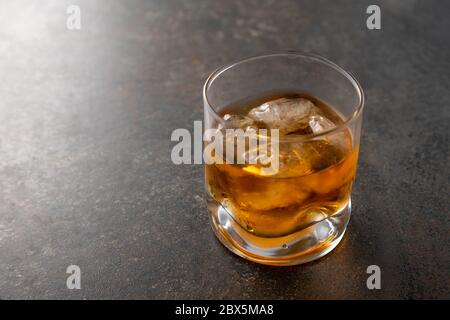 Verre de whisky doré vieilli avec des glaçons sur la table. Boisson alcoolisée de couleur ambre avec rochers au bar Banque D'Images