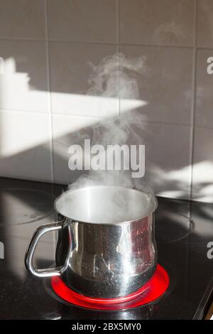 Casserole d'eau bouillante sur une cuisinière électrique. Banque D'Images