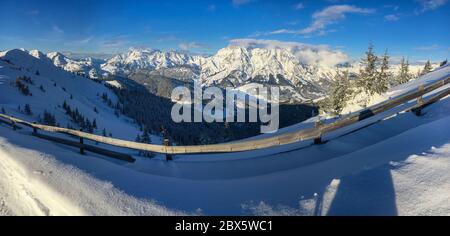 Vue panoramique sur les montagnes enneigées de Leogang (à droite) et les montagnes Lofer (à gauche) dans les alpes Austrain contre le ciel bleu Banque D'Images