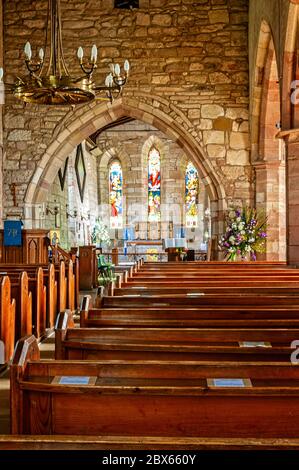 L'extrémité est de l'église a trois belles vitraux victoriens et un reredos derrière le haut autel représentant des saints liés à Iona Banque D'Images