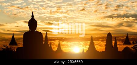 Silhouette de Bouddha sur fond de coucher de soleil de temple doré. Attraction touristique en Thaïlande. Banque D'Images