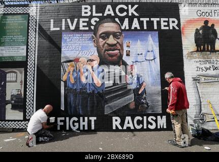 NOTEZ LE CONTENU GRAPHIQUE SUR LES artistes DE LA FRESQUE Lyonsie (à gauche) et Micky Doc ont mis la touche finale à une fresque de George Floyd au mur international de Belfast sur la route des chutes. M. Floyd a été tué le 25 mai alors qu'il était en garde à vue dans la ville américaine de Minneapolis. La fresque a été commandée par Feile an Phobail et Failte Feirste Thiar, et peinte par Marty Lyons et Micky Doherty. Banque D'Images