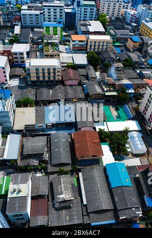 Vue depuis le haut étage des rues de Bangkok. Grands bâtiments et toits de petites maisons. Paysage urbain. Banque D'Images