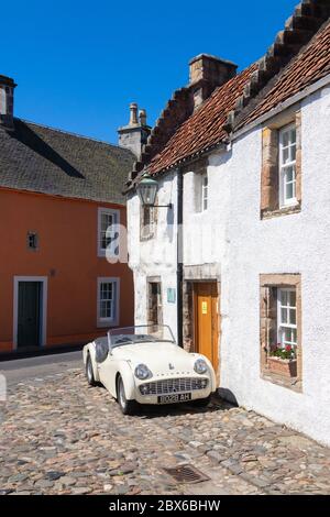 Une voiture de sport Triumph TR3A 1959 devant une ancienne maison traditionnelle dans le beau village de Culross, Fife, Écosse. Banque D'Images