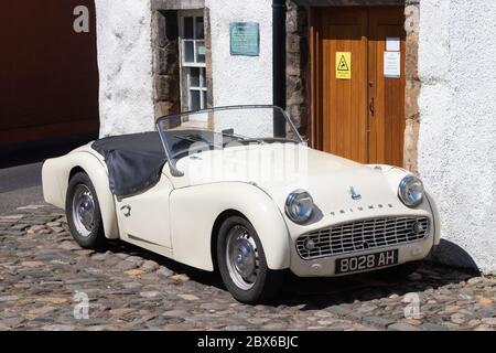 Une voiture de sport Triumph TR3A 1959 devant une ancienne maison traditionnelle dans le beau village de Culross, Fife, Écosse. Banque D'Images