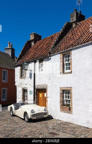 Une voiture de sport Triumph TR3A 1959 devant une ancienne maison traditionnelle dans le beau village de Culross, Fife, Écosse. Banque D'Images