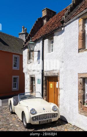 Une voiture de sport Triumph TR3A 1959 devant une ancienne maison traditionnelle dans le beau village de Culross, Fife, Écosse. Banque D'Images